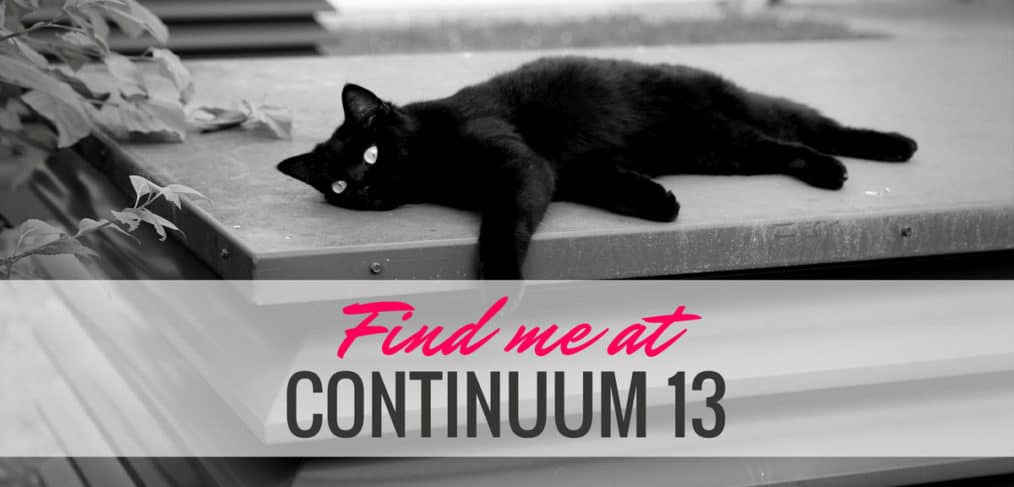 A black cat lazes on concrete